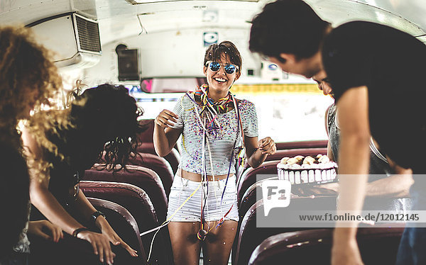Eine junge Frau feiert in einem Bus Geburtstag.
