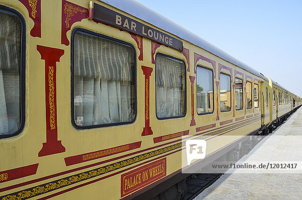 Zugwaggons in den Farben Rot und Gelb  auf einem Bahnhof in Rajasthan. Der Palast auf Rädern. Der Barwagen.