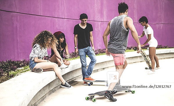 A group of young skateboarders in a skate park.