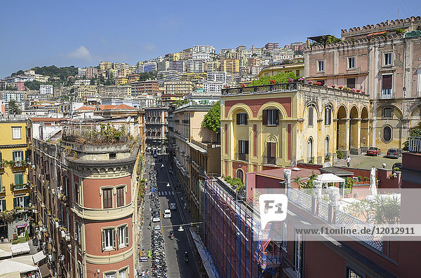 Erhöhte Ansicht traditioneller Gebäude und Dachterrassen mit farbenfrohen Verputzarbeiten am Hang in Neapel.