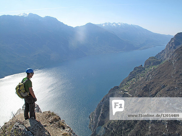 North Italy  Trent province Garda Lake  a man wearing a helmet stands on a rock above the Garda lake
