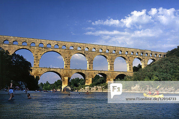 Frankreich  Südfrankreich  Pont du Gard  römisches Aquädukt aus dem I. Jahrhundert am Fluss Gardon. Gesamtansicht von oben auf das Wasser mit Schwimmern und Kanus.