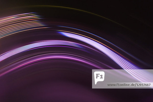 Vollbildabstraktes Bild von violetten Lichtspuren auf schwarzem Hintergrund
