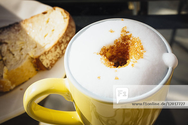 Blick auf frischen  schaumigen Kaffee mit braunem Zucker auf dem Tisch im Cafe
