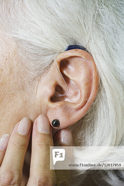 Abgeschnittenes Bild einer älteren Frau mit Hörgerät