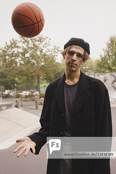 Portrait eines jungen Mannes beim Basketball im Park