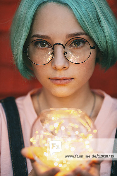 Teenagermädchen mit Brille und beleuchteten Lichterketten