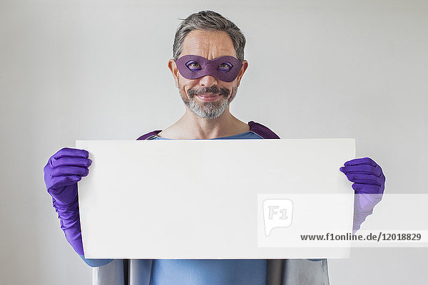 Porträt eines Superhelden mit leeren Plakaten auf weißem Hintergrund