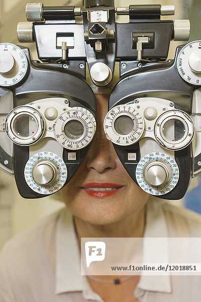 Close-up of smiling senior woman getting vision examination at clinic