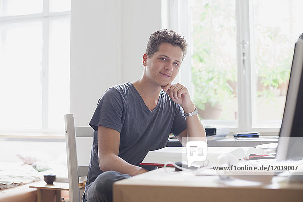 Portrait of handsome young male university student studying at home