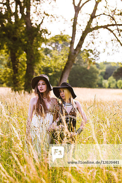Porträt von zwei jungen Mädchen in einem Feld  die in die Ferne schauen