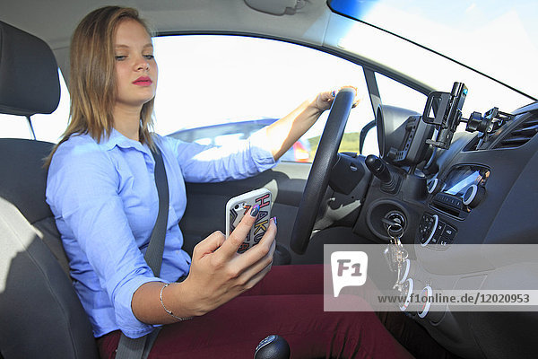 France woman using smartphone in her car.