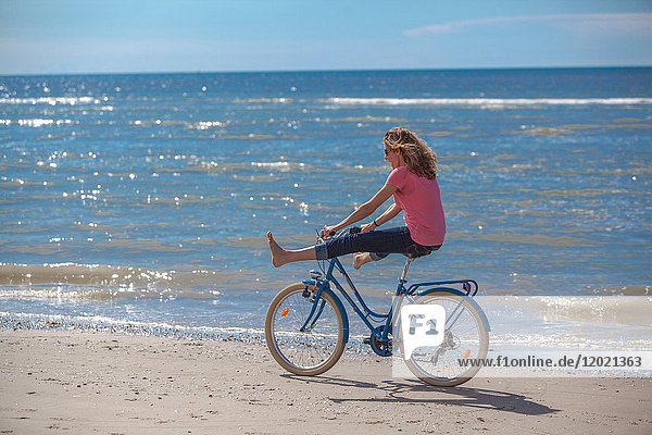 Young women riding a bike on the beach  Pas de Calais  Bitch.