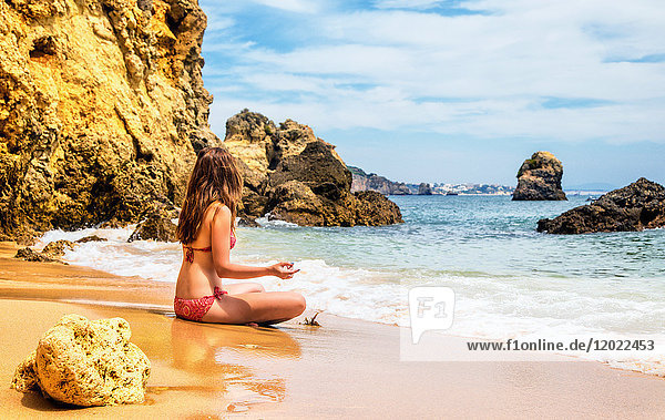 Junge Frau beim Meditieren in der Bucht von Praia de Galapinhos  Setubal  Region Lissabon  Portugal
