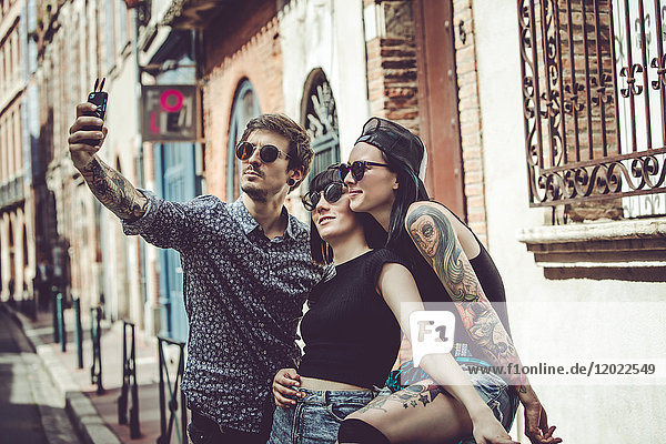 Selfie of three young people in an urban landscape