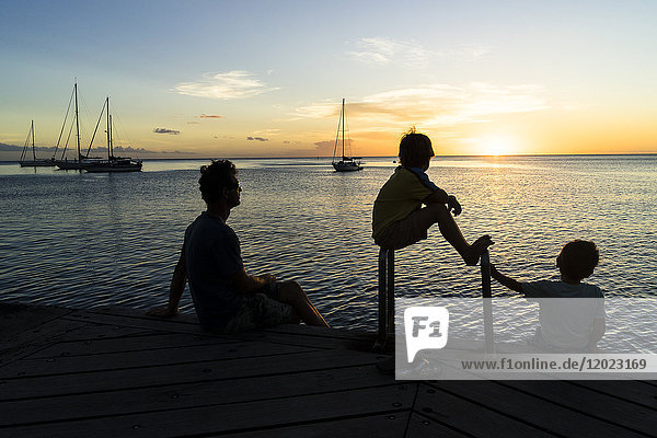 A father and his two sons looking at the sunset  Saint-Pierre  Martinique  France