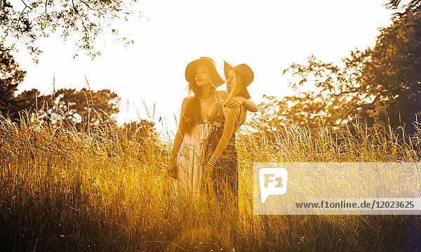 Porträt von zwei jungen Mädchen in einem Feld  die in die Ferne schauen