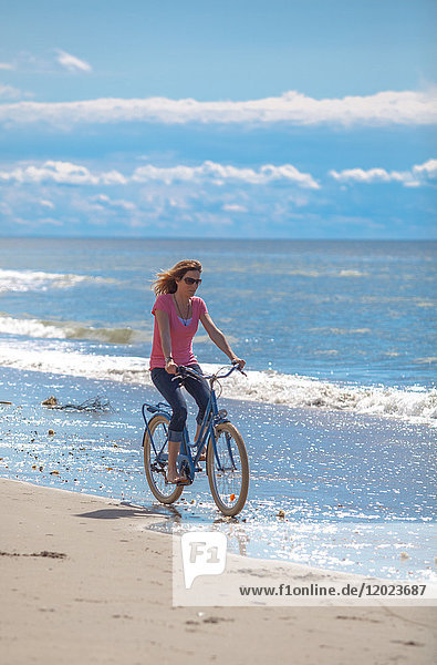 Young women riding a bike on the beach  Pas de Calais  Bitch.