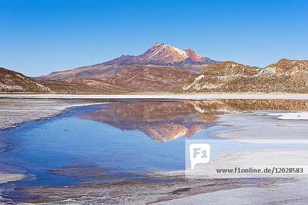 Volcano Cerro Tunupa with reflection in the Salar de Uyuni  Altiplano  3670 m above sea level  Bolivia  South America