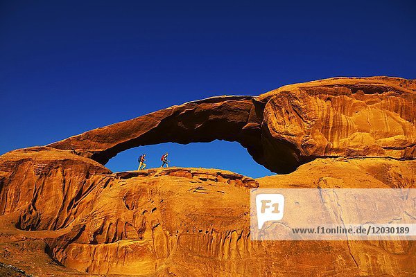 Couple hiking at Rock-Arch Al Kharza  Wadi Rum  Jordan  Middle East  Asia