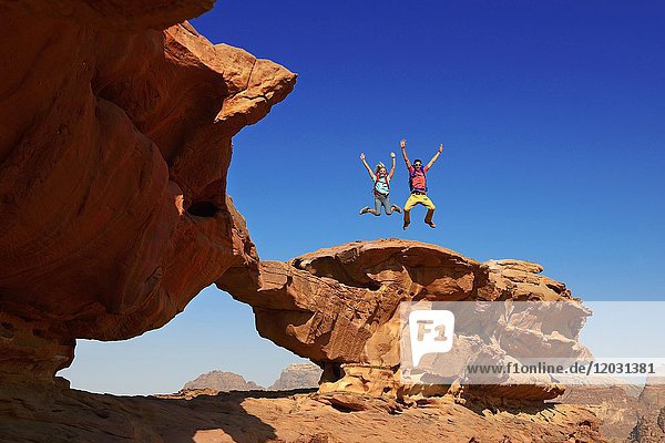 Couple hiking at Rock Arch  Al Borg Alsagheer  Wadi Rum  Jordan  Asia