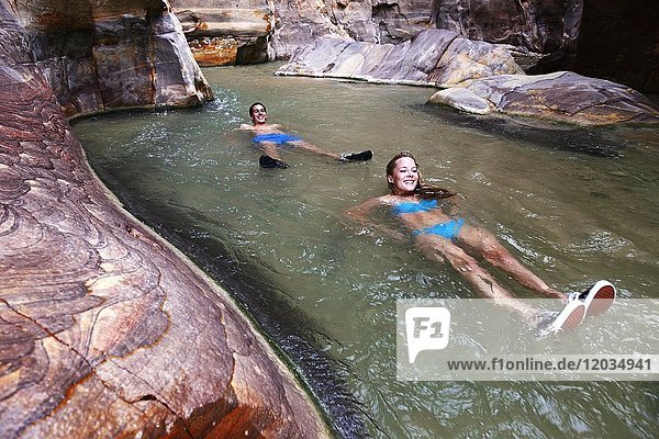 Young couple floats at the canyon of Wadi Mujib  Jordan  Asia