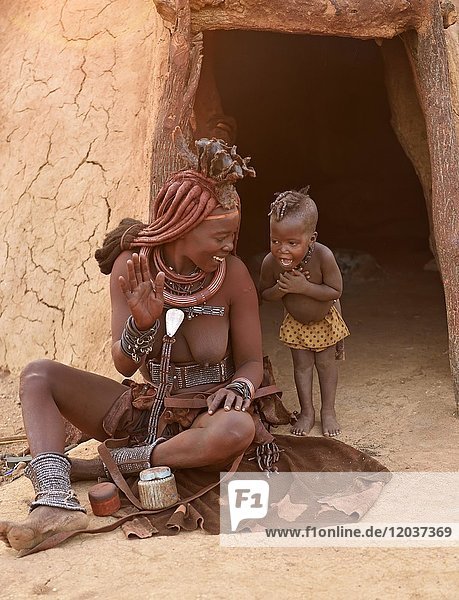 Himba woman with child in front of the mud hut  Kaokoveld  Namibia  Africa