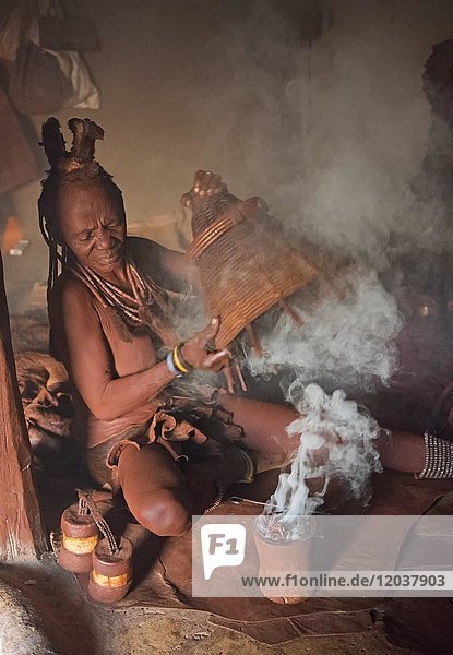 Himbafrau  beim Desinfizieren von Kleidung  Kaokoveld  Namibia  Afrika