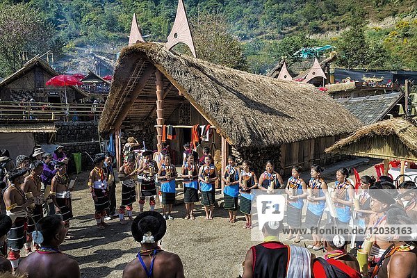 Naga Stammesangehörige vor einem traditionellen Haus  Kisima Nagaland Hornbill Festival  Kohima  Nagaland  Indien  Asien