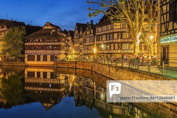 People on a restaurant terrace along the ILL canal at twilight  Strasbourg  Alsace  Bas-Rhin Department  France  Europe