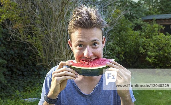 Young man eating a melon  Bavaria  Germany  Europe