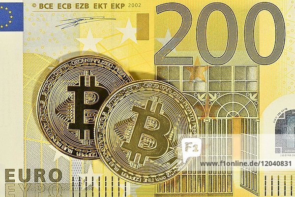 Symbolbild digitale Währung  goldene physische Münze Bitcoin vor 200 EURO Banknote