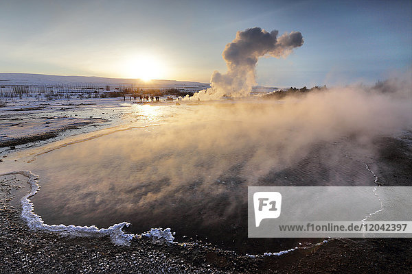 Heiße Becken und Dampf von Strokkur Geysir bei Sonnenaufgang  Winter  im geothermischen Gebiet neben dem Fluss Hvita  Geysir  Island  Polarregionen