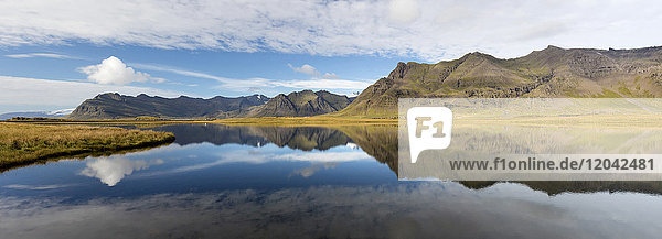 Panoramic view of mountains and blue sky reflecting in lake near Vik South Iceland Polar Regions