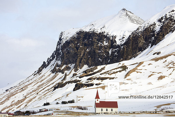 Rote und weiße Kirche vor schneebedeckten Bergen  Vik  Südisland  Polarregionen