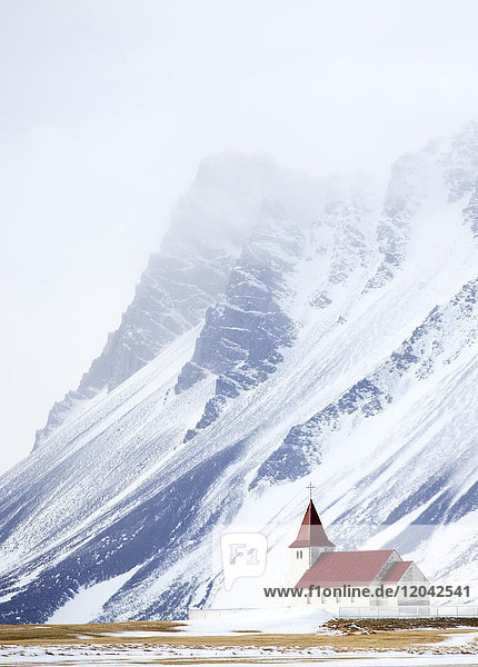 Kirche vor schneebedeckten Bergen  Winternachmittag  Halbinsel Snaefellsnes  Island  Polarregionen
