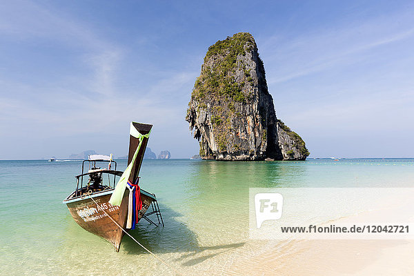 Traditional Longtail boat moored by Phra Nanag Beach with limestone islands in the background Krabi Thailand Southeast Asia Asia