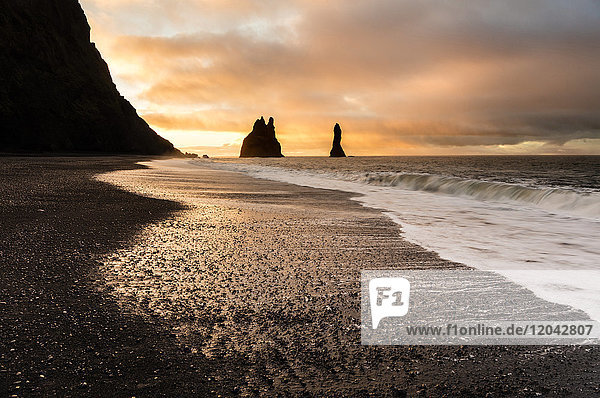 Rock stacks of Reynisdrangar at sunrise from Halsanefs Hellir Beach near Vik South Iceland Polar Regions