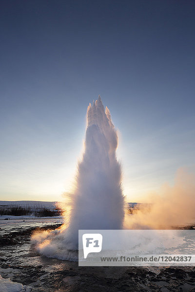 Strokkur Geysir erupting at sunrise during winter geothermal area beside the Hvita River Geysir Iceland Polar Regions