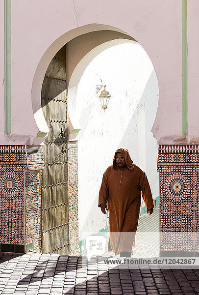 Einheimischer in traditioneller Djellaba gekleideter Mann verlässt die Moschee in der Kasbah  Marrakesch  Marokko  Nordafrika  Afrika