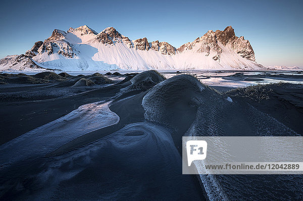 Frozen winter landscape at dusk with Vestrahorn mountains in distance Stokksnes South Iceland Polar Regions