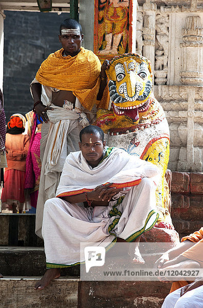 Hindu pilgrims in saffron and white robes  at the gate into Kapilash Temple (Chandrashekhar Temple)  Dhenkanal District  Odisha  India  Asia