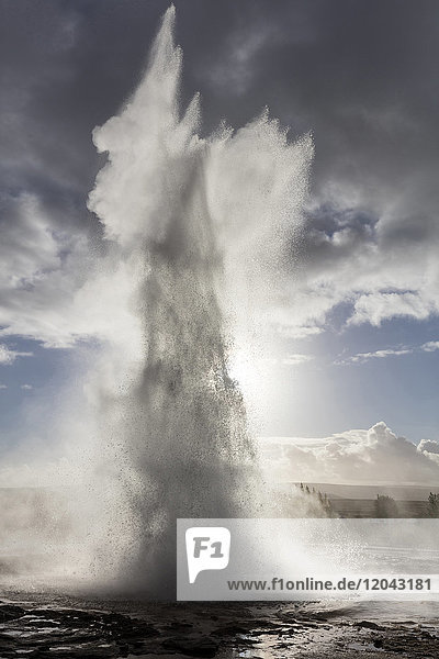 Strokkur Geysir bricht vor stürmischem Himmel aus  Geysir  Südwestisland  Polarregionen