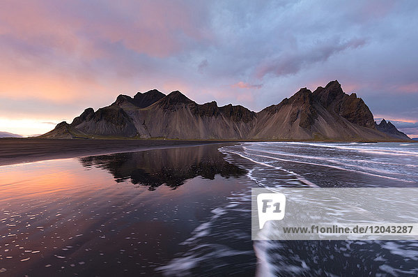 Blick auf die Berge von Vestrahorn vom schwarzen Vulkansandstrand bei Sonnenuntergang  Stokksnes  Südisland  Polarregionen
