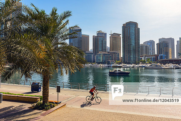 Ein einsamer Radfahrer fährt entlang der Uferpromenade  Dubai Marina  Dubai  Vereinigte Arabische Emirate  Naher Osten