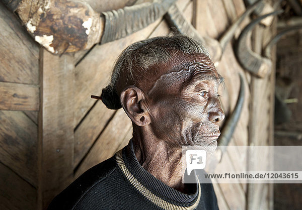 Bengshe Bengsha  älterer Kopfjäger eines Naga-Stammes mit traditionell tätowiertem Gesicht und Haarknoten  Dorf Longwa  Nagaland  Indien  Asien