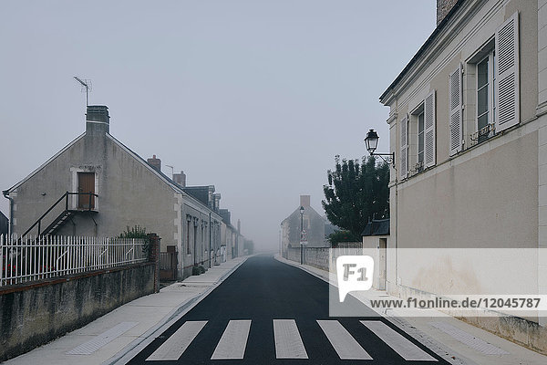 Leere Straße durch das Dorf Meigne-le-Vicomte an einem nebligen Morgen,  Loire-Tal,  Frankreich