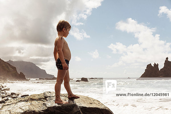Young boy standing on rock looking at view Santa Cruz de Tenerife Canary Islands Spain Europe