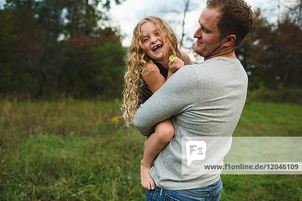 Vater und Tochter geniessen die freie Natur auf grünem Grasfeld