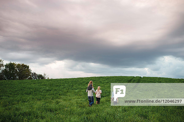 Fünfköpfige Familie geniesst die freie Natur auf grünem Grasfeld